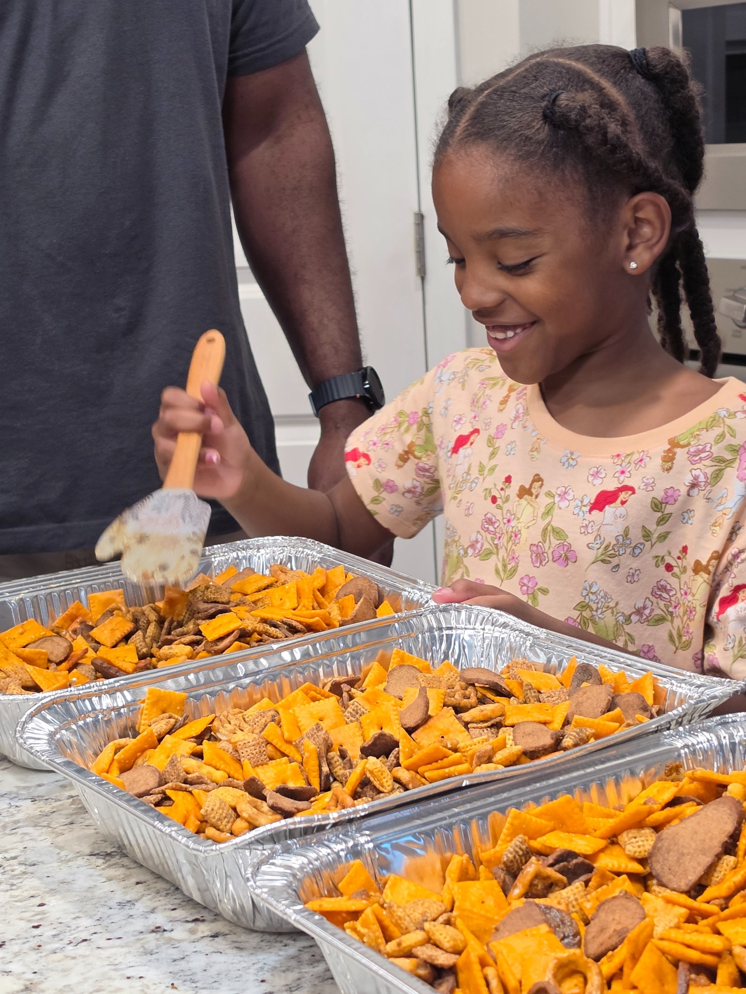 Luna helping mix a batch of Luna & Dad Smokehouse smoked snack mix in the family kitchen.